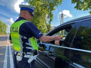 Policjant bada stan trzeźwości kierowcy