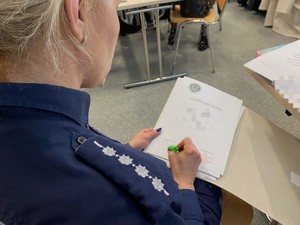 Policjantka składa podpis na dokumencie