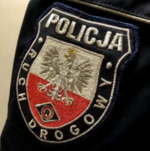 Emblemat Policja Wydział Ruchu Drogowego z godłem Polski i oznaczeniem rodzaju służby, umieszczony na rękawie kurtki policjanta.