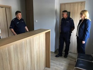 Wnętrze pomieszczenia, w którym stoją i rozmawiają: umundurowany policjant, Burmistrz Stawisk oraz Komendant Powiatowy Policji w Kolnie.