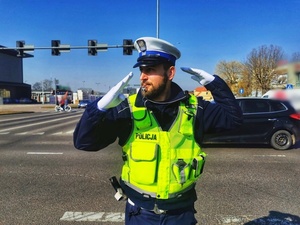Policjant na drodze kieruje ruchem.