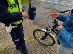 Policjant daje odblask rowerzystce.