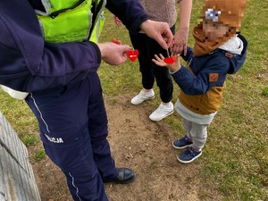 Policjant daje odblask małemu chłopcu.