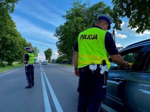 Policjanci przy pomocy urządzeń badają stan trzeźwości kierowców samochodów osobowych