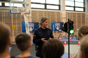 Policjantka z dziećmi na sali gimnastycznej.