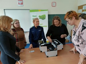 Policjantka i nauczycielki wokół walizki edukacyjnej