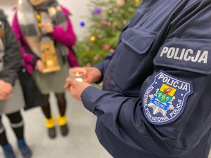 Policjant trzyma w dłoniach światełko pokoju