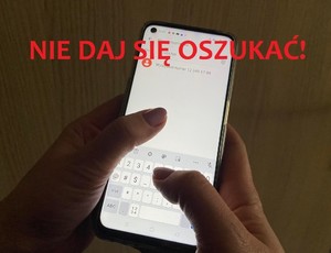 Telefon komórkowy trzymany w dłoniach. Napis: Nie daj się oszukać!