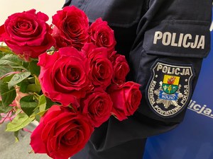 Policjantka trzyma bukiet różowych róż