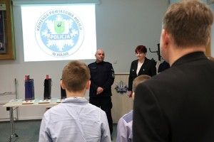 Komendant Powiatowy Policji w Kolnie stojąc mówi do dwóch chłopców i mężczyzny. Obok niego stoi kobieta.