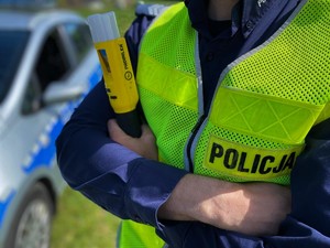 Policjant trzyma alkomat trzyma urządzenie do badania stanu trzeźwości