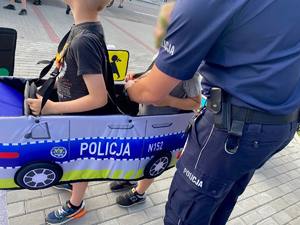 Policjant i dwóch chłopców w autochodziku