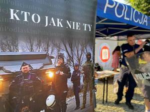 Na pierwszym planie rollup z napisem: Kto jak nie ty. W tle policjant i chłopiec