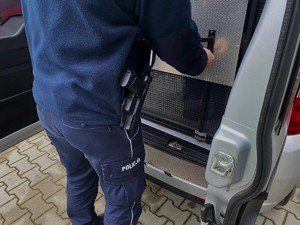 Policjant zamyka drzwi radiowozu