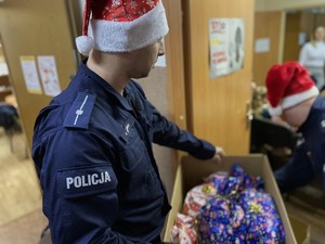 Policjant w czapce Mikołaja z prezentami