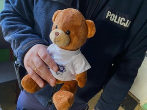 Policjant trzymający pluszowego misia