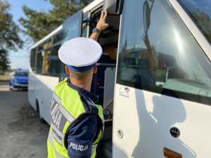 Policjant sprawdza ustawienie lusterka w gimbusie