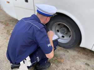 Policjant sprawdza stan ogumienia w gimbusie