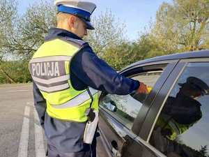 Policjant przeprowadza kontrole stanu trzeźwości kierowcy osobówki