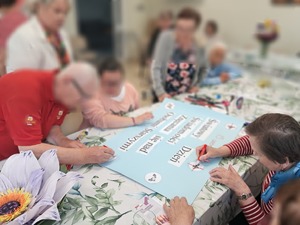 seniorzy przygotowujący plakat informacyjny