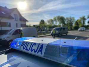 Dach radiowozu. W tle policjanci badają trzeźwość kierowców