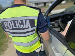 Policjant przy samochodzie osobowym