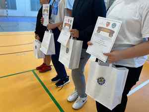 Dzieci trzymają dyplomy i torby z nagrodami