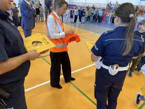 Policjanci w szkole rozdają elementy odblaskowe