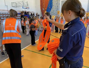 Policjanci w szkole rozdają elementy odblaskowe