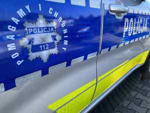 Drzwi radiowozu. Napis: Pomagamy i Chronimy. Policja 112.