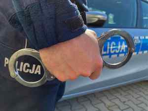 Kajdanki trzymane w dłoni przez policjanta