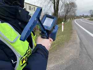Policjant przy drodze z ręcznym miernikiem prędkości