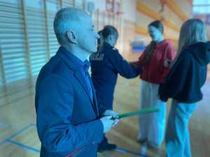 Policjantka w szkole rozdaje opaski odblaskowe