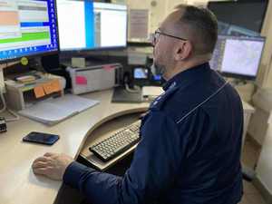 Policjant siedzący przed ekranami monitorów