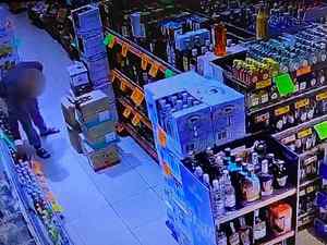 Zrzut ekranu z nagranie kamery monitoringu. Na nim mężczyzna w sklepie przy półkach z alkoholem.