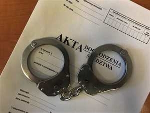 Okładka akt dochodzenia/ śledztwa. Na niej kajdanki.