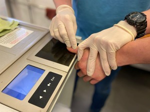 Policjant pobiera od zatrzymanego odciski linii papilarnych