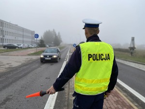 Policjant na drodze zatrzymuje samochód osobowy do kontroli