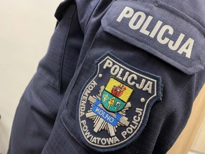 Emblemat Komendy Powiatowej Policji w  Kolnie na lewym przedramieniu policjanta
