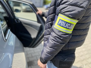 Policjant kryminalny przy nieoznakowanym radiowozie