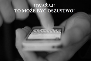 Uważaj! To może być oszustwo! Mężczyzna trzyma telefon komórkowy w dłoniach.