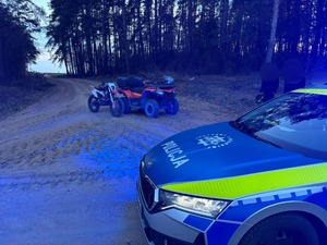 Radiowóz, motocykl i quad na drodze  w rejonie lasu