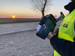 Policjant przy drodze z ręcznym miernikiem prędkości