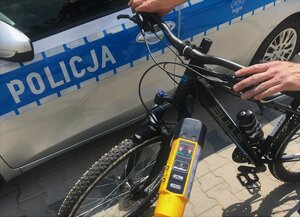 Mężczyzna z rowerem przy radiowozie